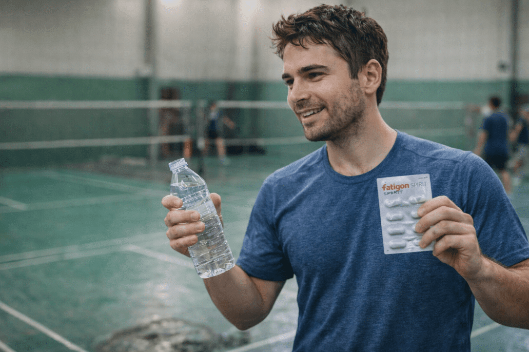Man holding a water bottle for badminton fitness and hydration